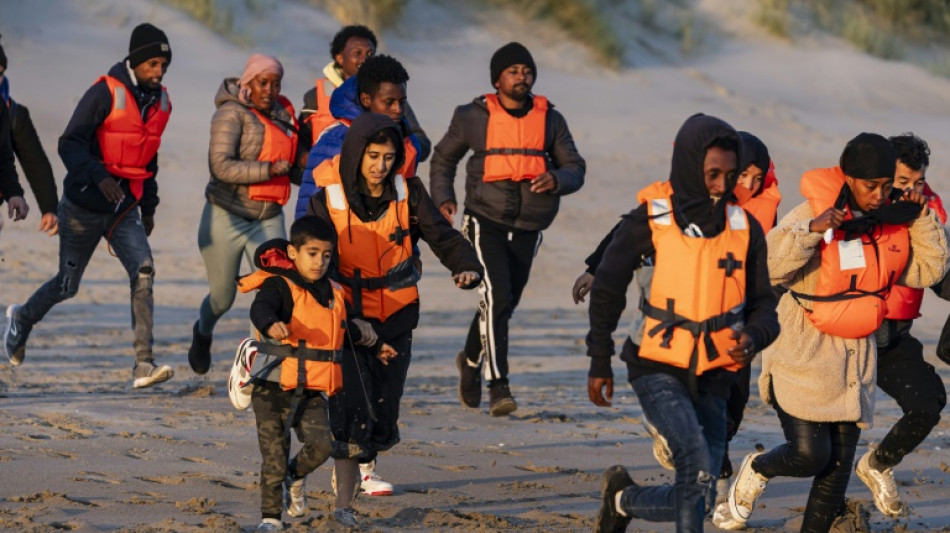 Inmigrantes con niños corren hacia abarrotadas barcas en el norte de Francia