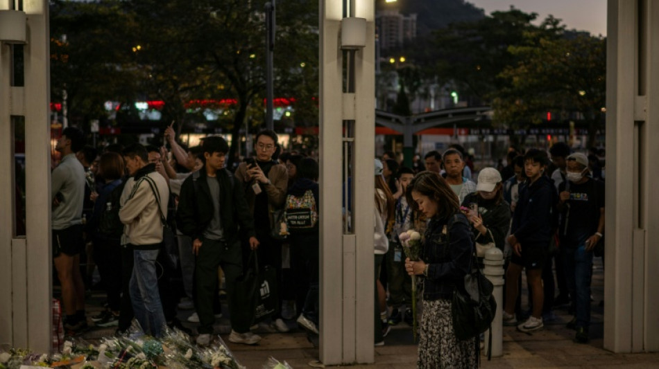 Stunned mourners gather outside ruins of Hong Kong housing estate blaze
