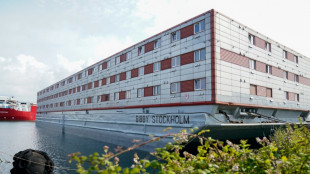 Contentious barge docked on UK coast begins hosting first migrants